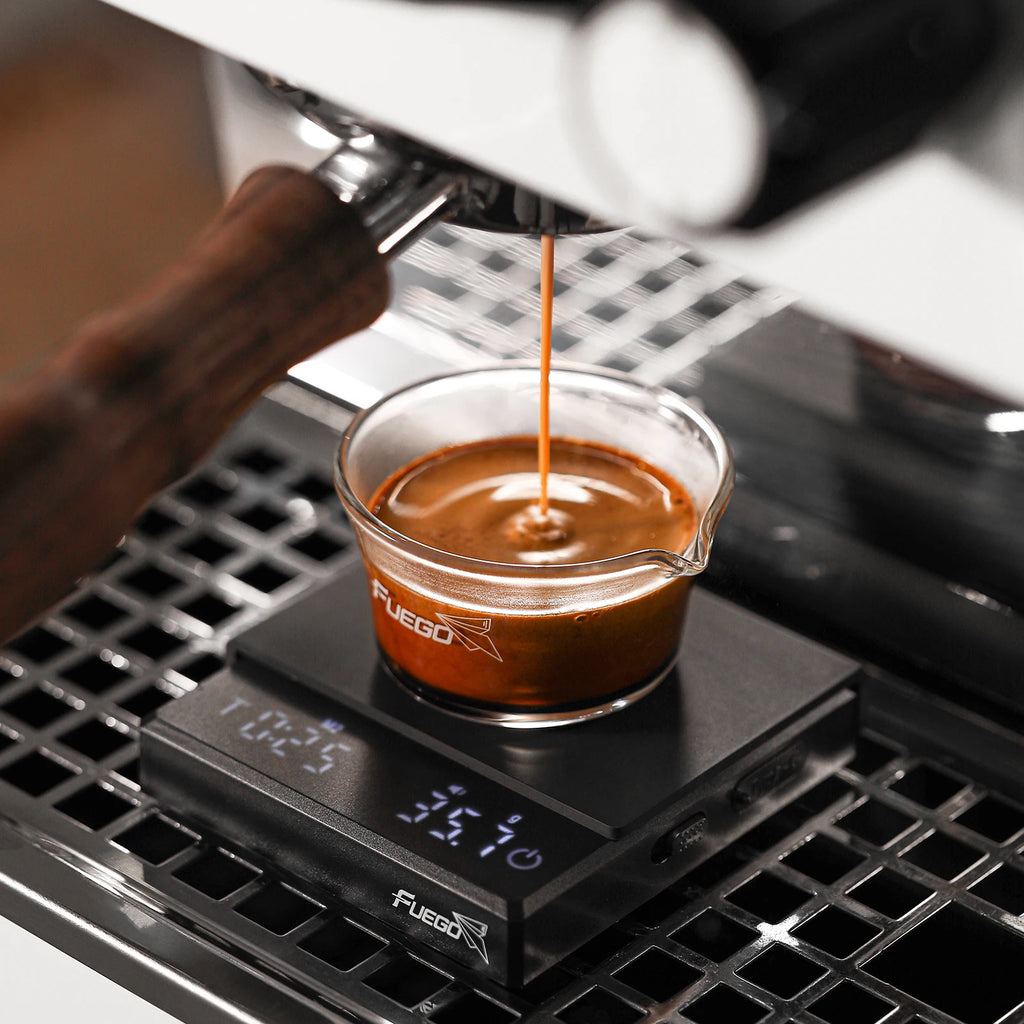 Espresso being poured into a glass container on a digital scale with 'Fuego' branding.