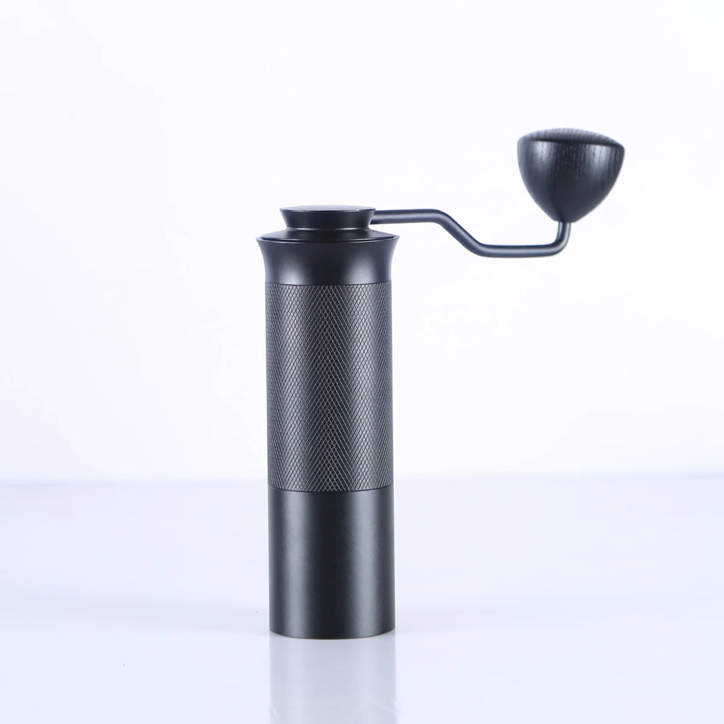 Black manual coffee grinder on a white background