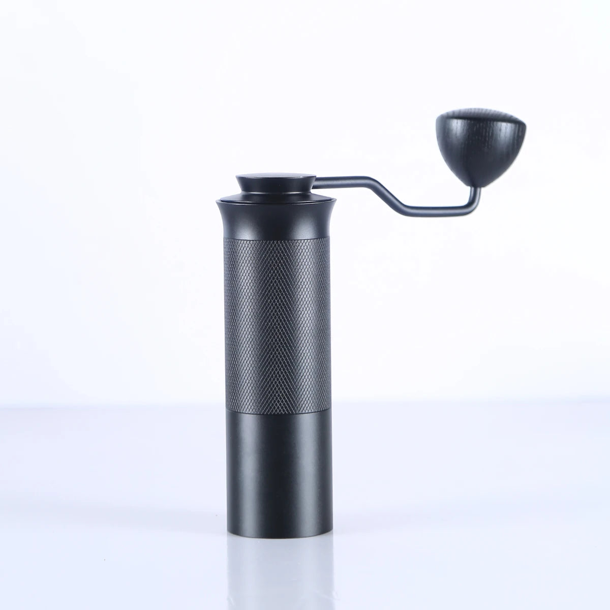 Black manual coffee grinder on a white background