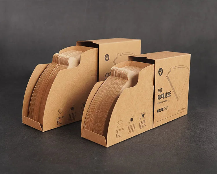 Two cardboard boxes with coffee filter packaging on a dark background