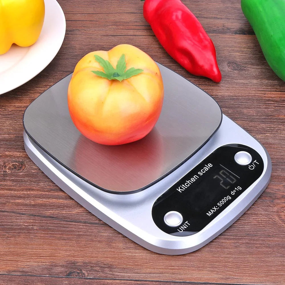 Digital kitchen scale with a tomato on a wooden surface