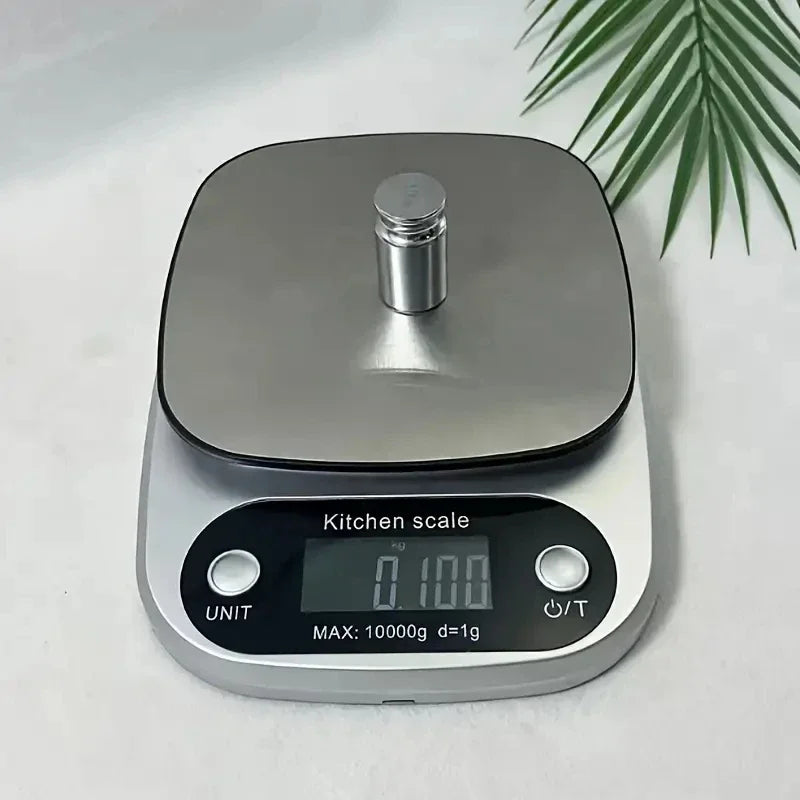 Digital kitchen scale on a light background with a leafy green plant.