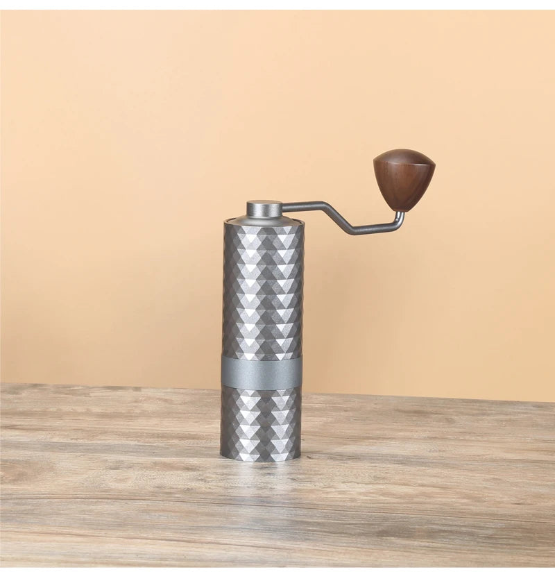 Metal coffee grinder with wooden handle on a wooden surface
